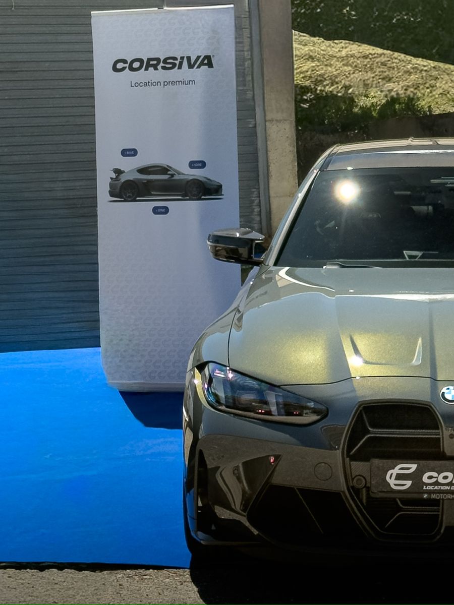 Totem Corsiva et BMW M3 sur tapis bleu lors d'un événement